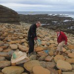 Teamwork to dislodge rope wedged under the rocks